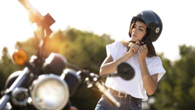 woman putting helmet on for a motorcycle road trip