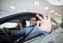 happy customer buying new car at dealership