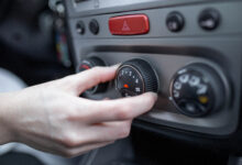 woman hand turning on car air conditioning system car air conditioner on off button close up view
